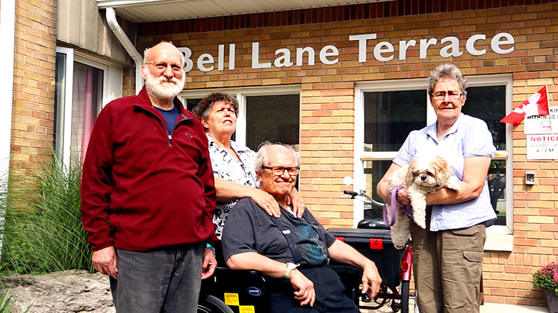 A group of tenants in front of the Bell Lane Terrace entrance.